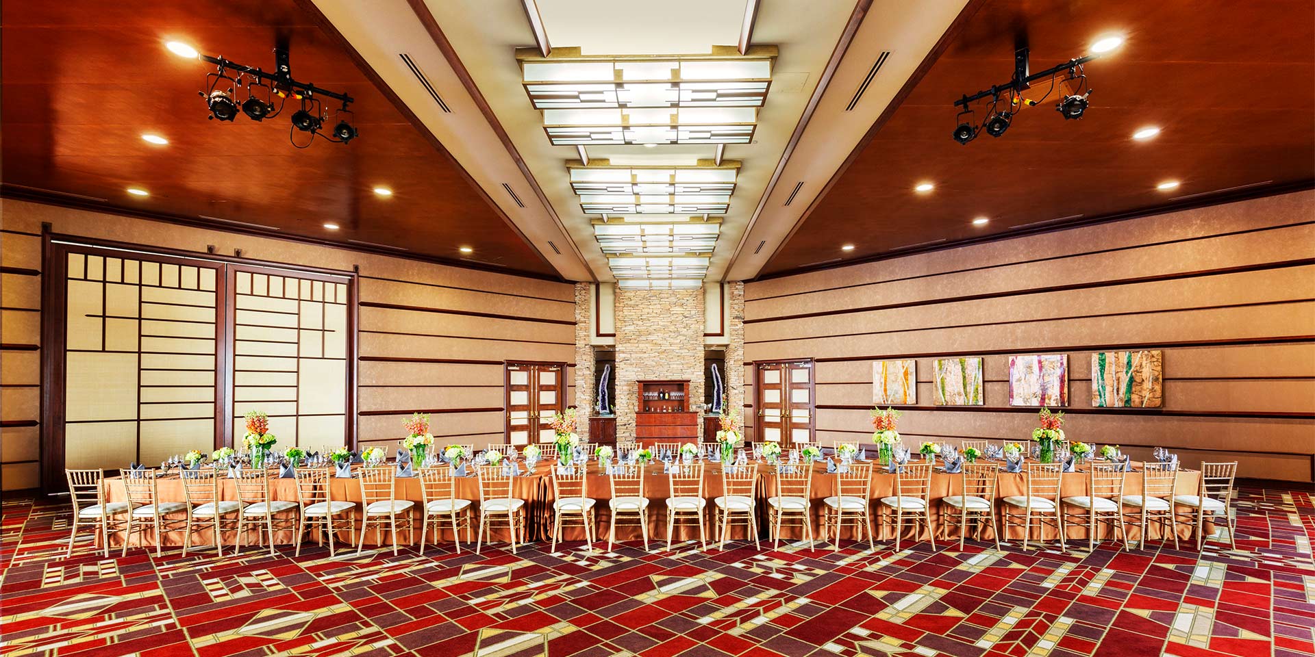 large room with red patterned carpet and tables with chairs
