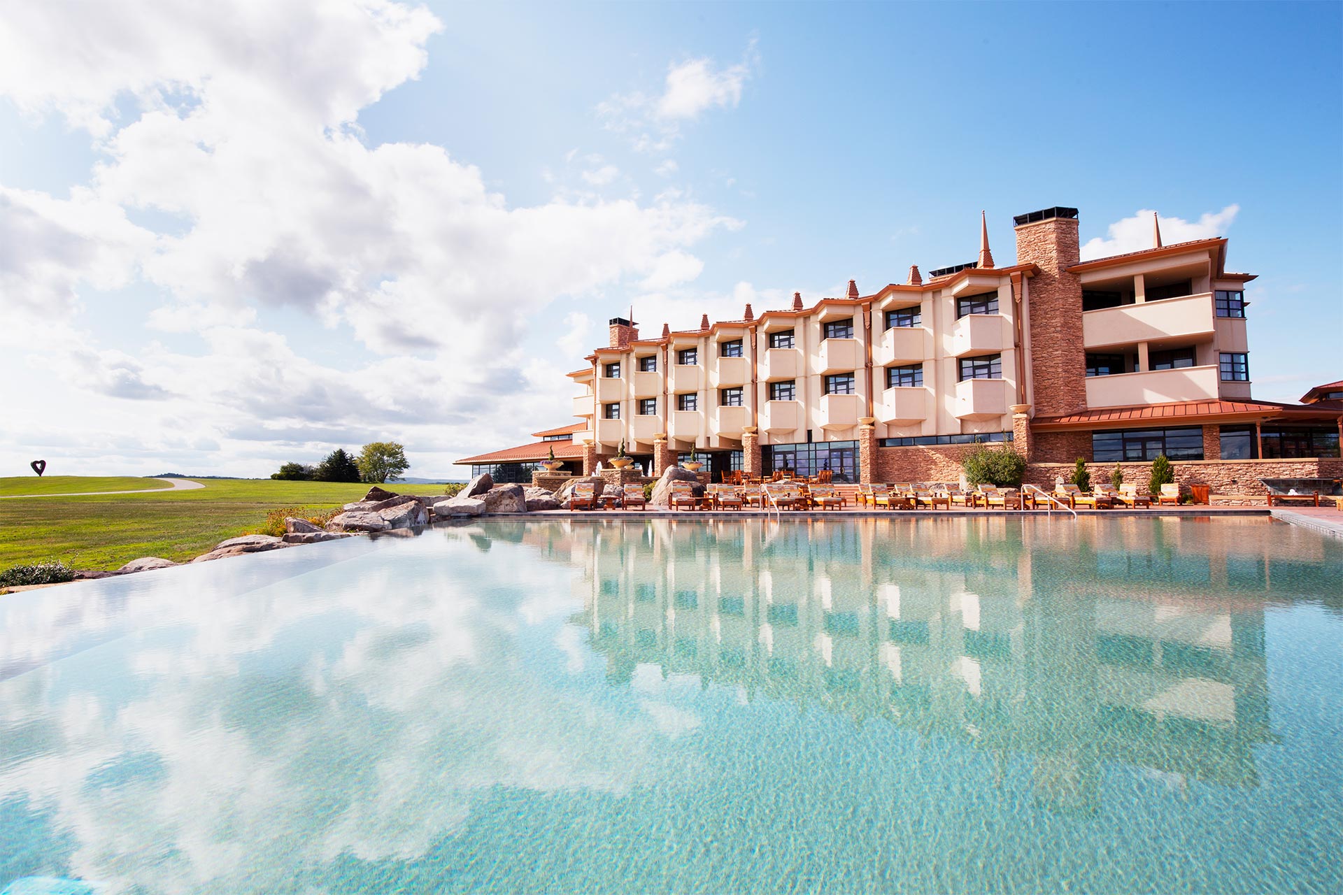 A large pool of water in front of a building with many windows