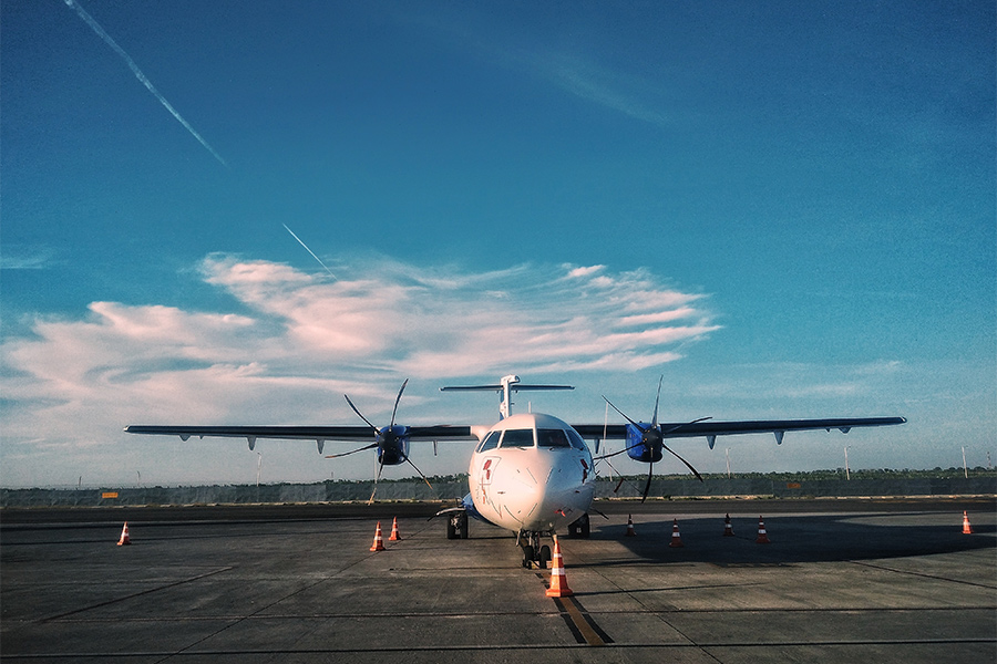 A airplane is surrounded by orange traffic cones as it is parked on the deck.